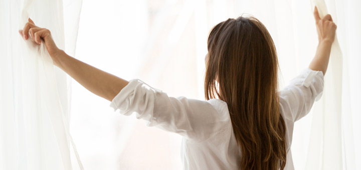 mujer cortinas ventana